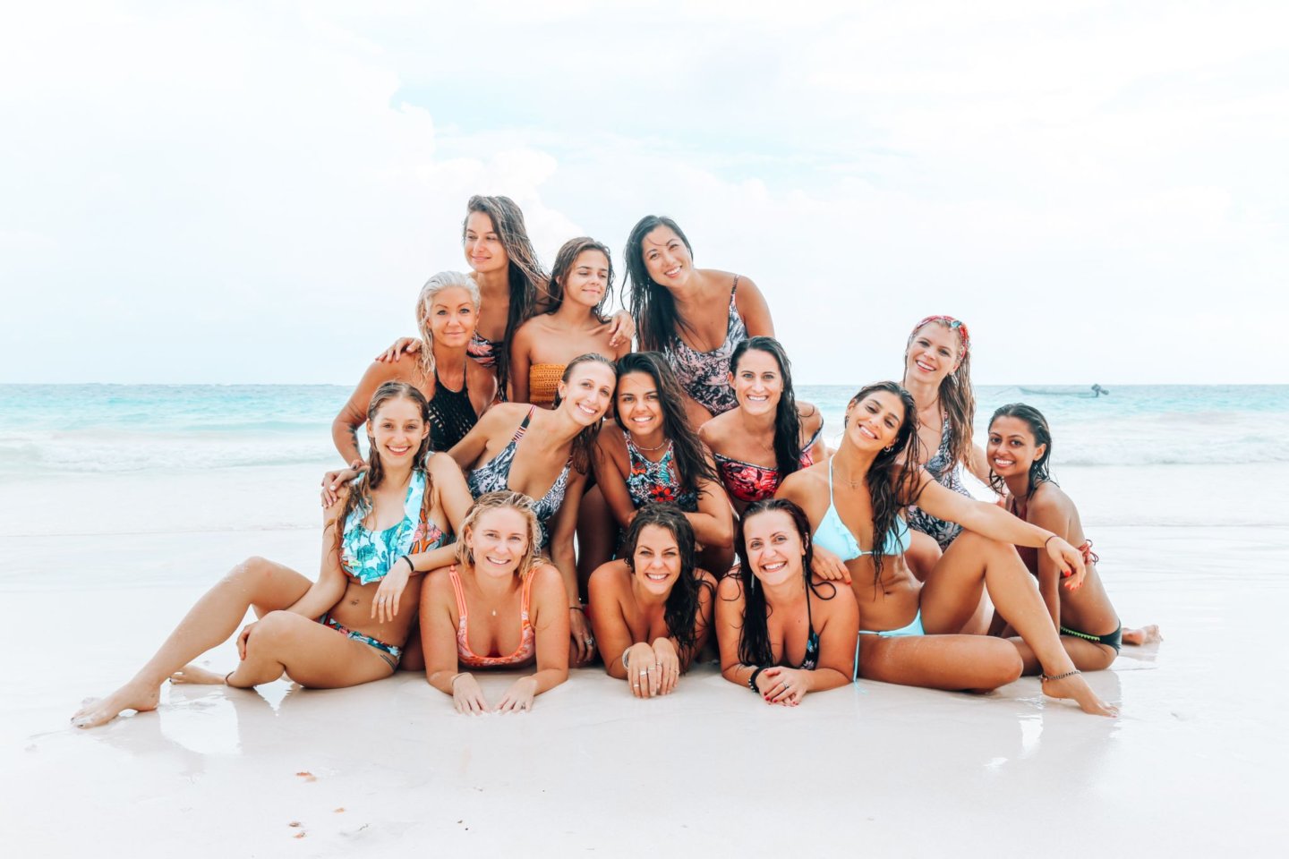 A group of women posing on a beach in Tulum, Mexico.