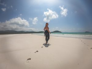 girl walking on Whitehaven Beach with footsteps behind her