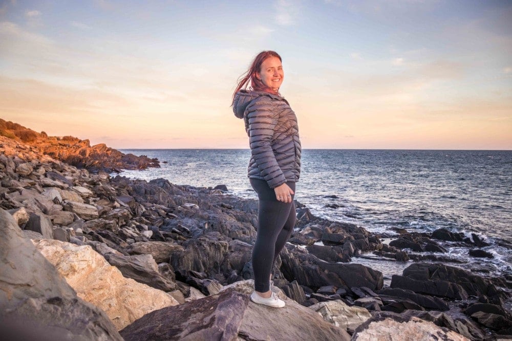 girl on rocks looking at sunrise over Kangaroo Island