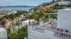 girl on balcony looking over Milos island