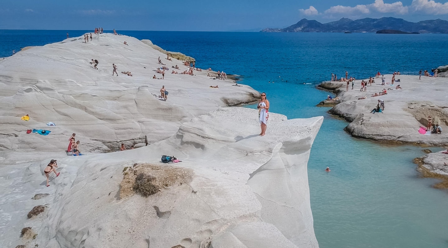 drone view of girl on a cliff on Sarakiniko beach in Milos