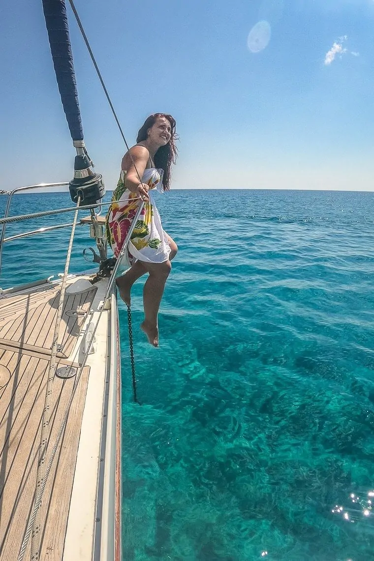 girl sitting on a sail boat at Gerakas beach in Milos