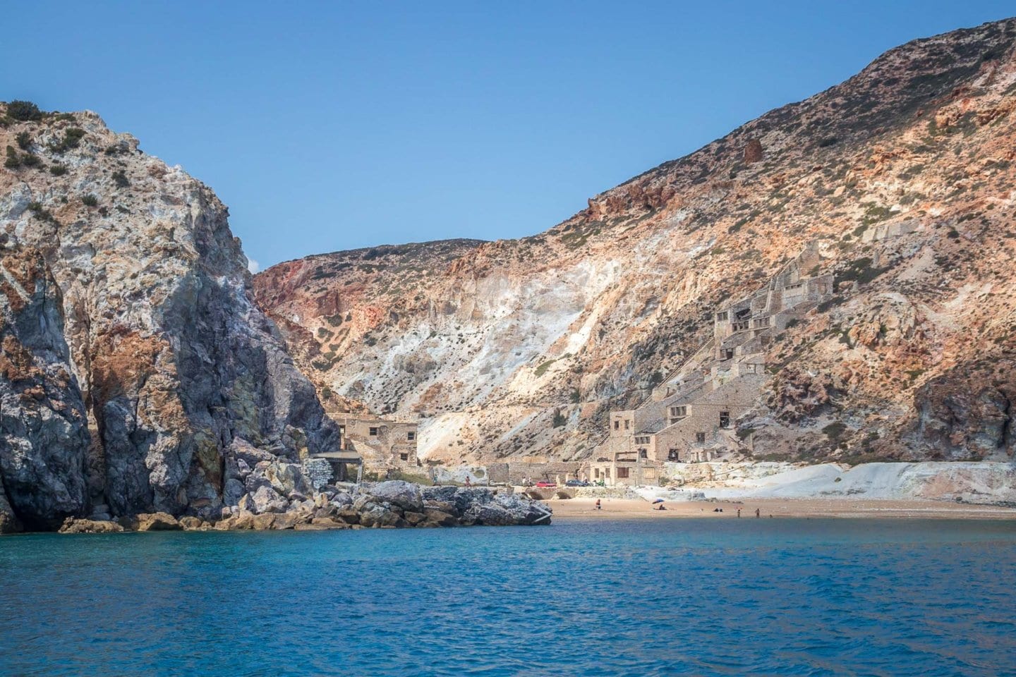 an abandoned sulfur mine nestled among volcanic rock formations seen from the sea
