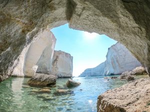 a bay surrounded by walls of rock seen from a cave