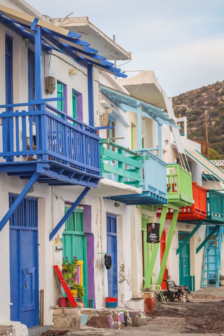 a row of colourful fishing houses in Milos, Greece