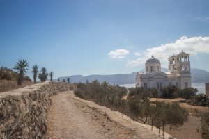 church peering over a village on top of the hill in Milos