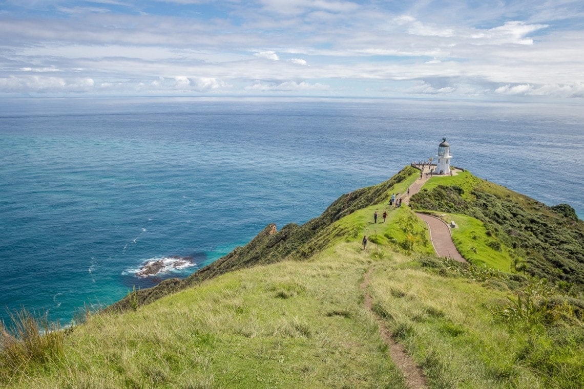 view of a lighthouse on a hilltop and the meeting point of Tasman Sea and Pacific Ocean