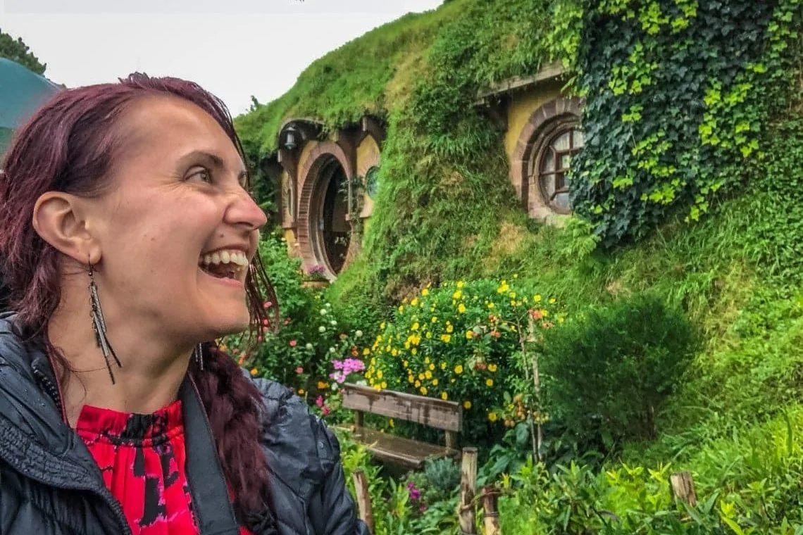 happy girl at Hobbiton with hobbit house in the background
