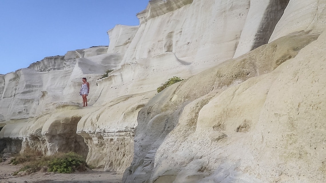 girl standing on rock formations in Milos