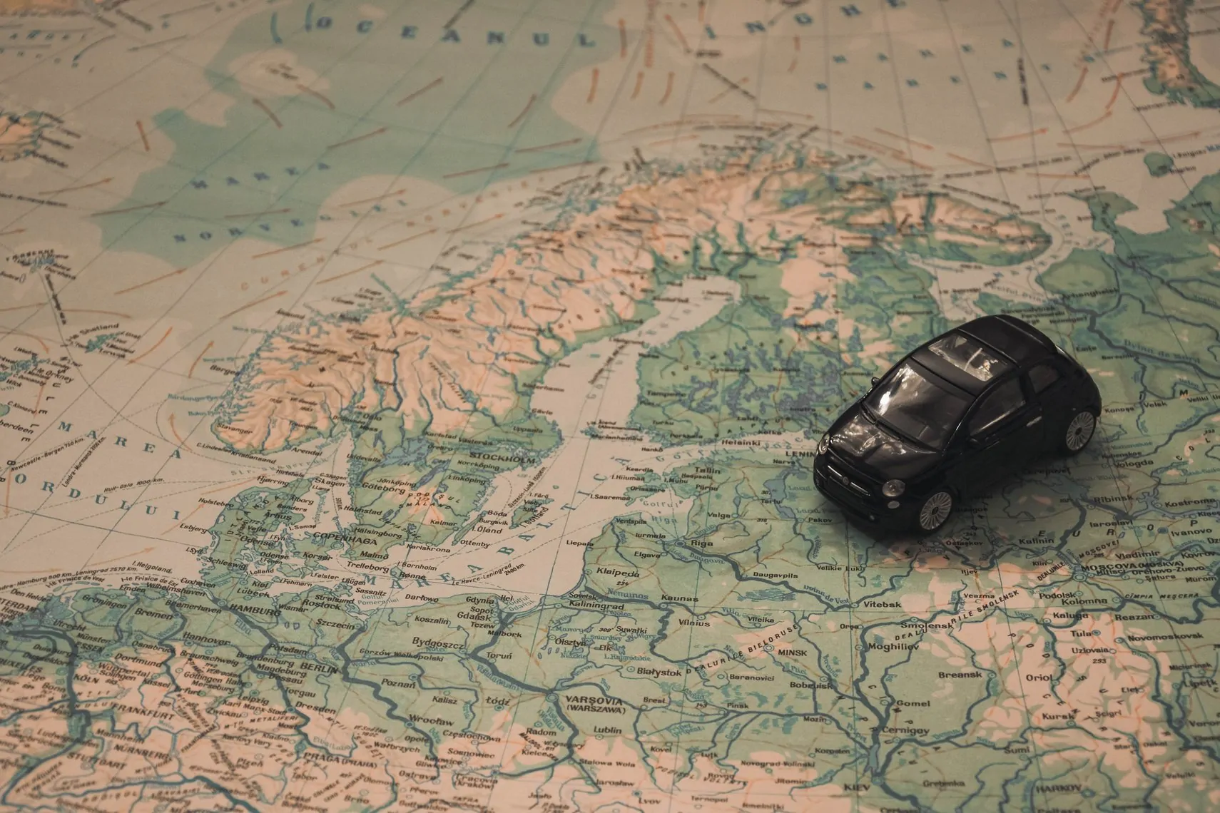 miniature black car on a map of the balkans