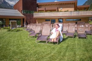 woman on a lawn chair in the garden at qc terme dolomiti