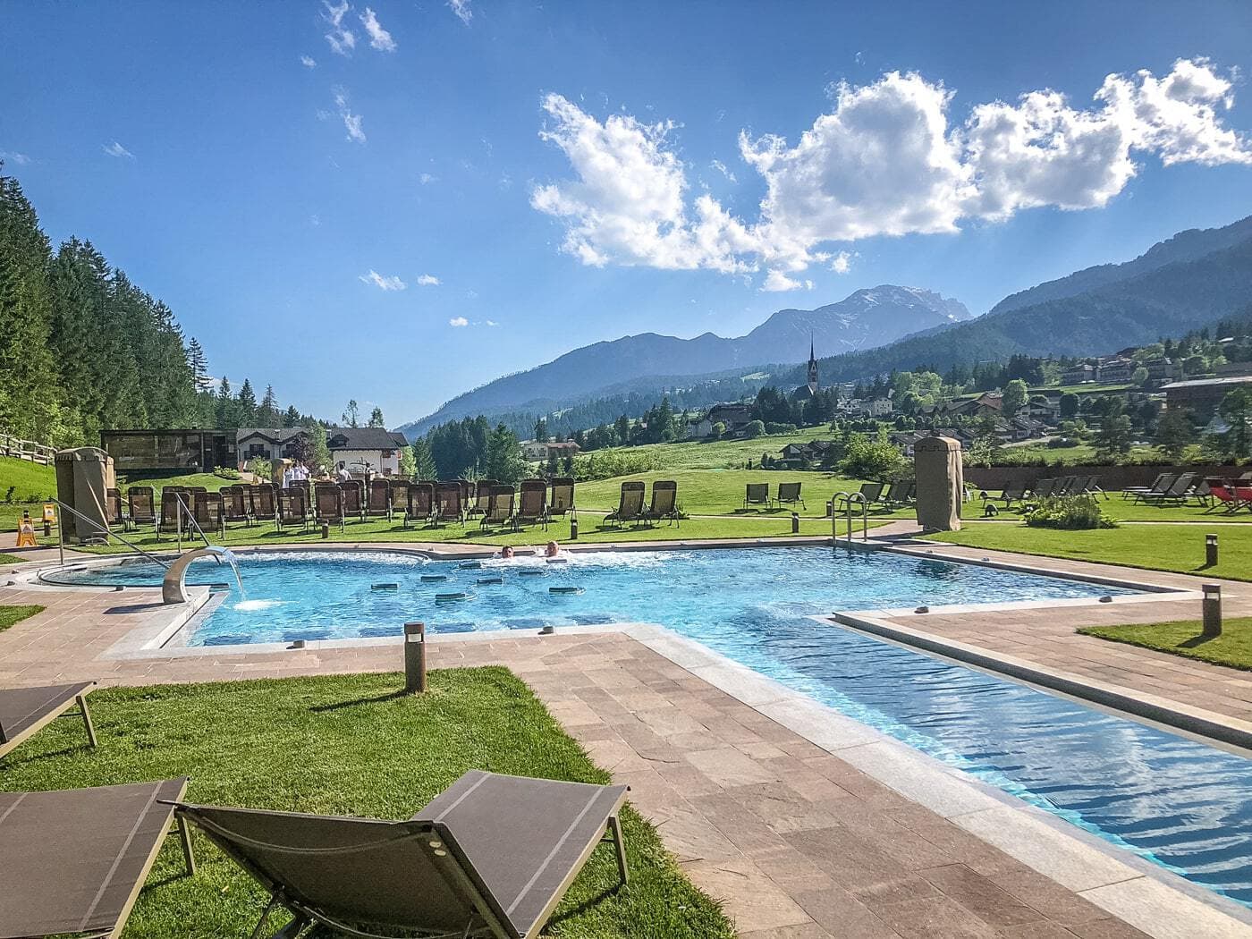 the pool outside of qc terme dolomiti  in val di fassa on a sunny day