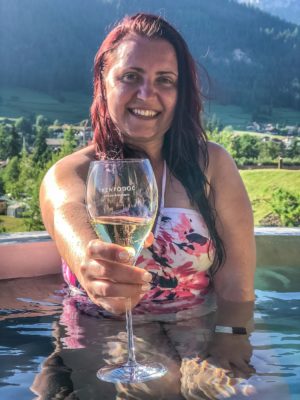 woman in a hot tub with a glass of trentodoc