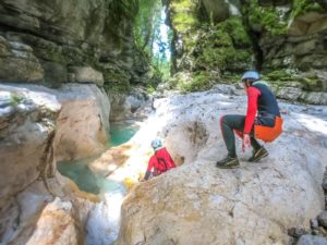 women sliding down canyoning walls in trentino