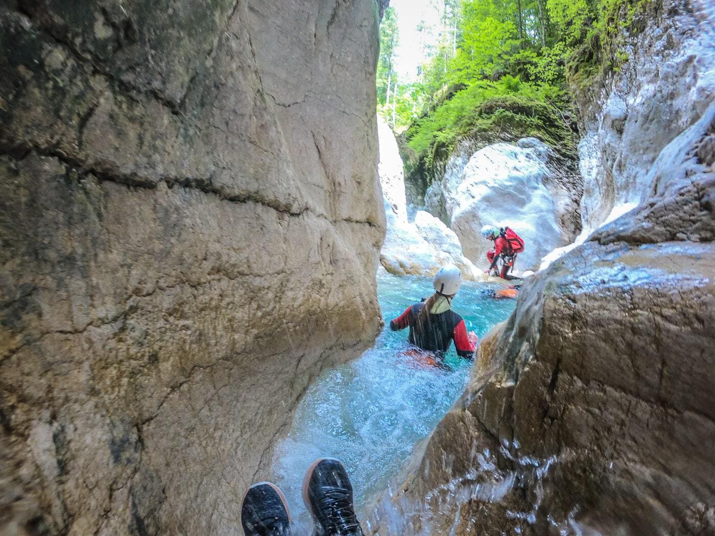 people sliding down a narrow canyon in noana valley
