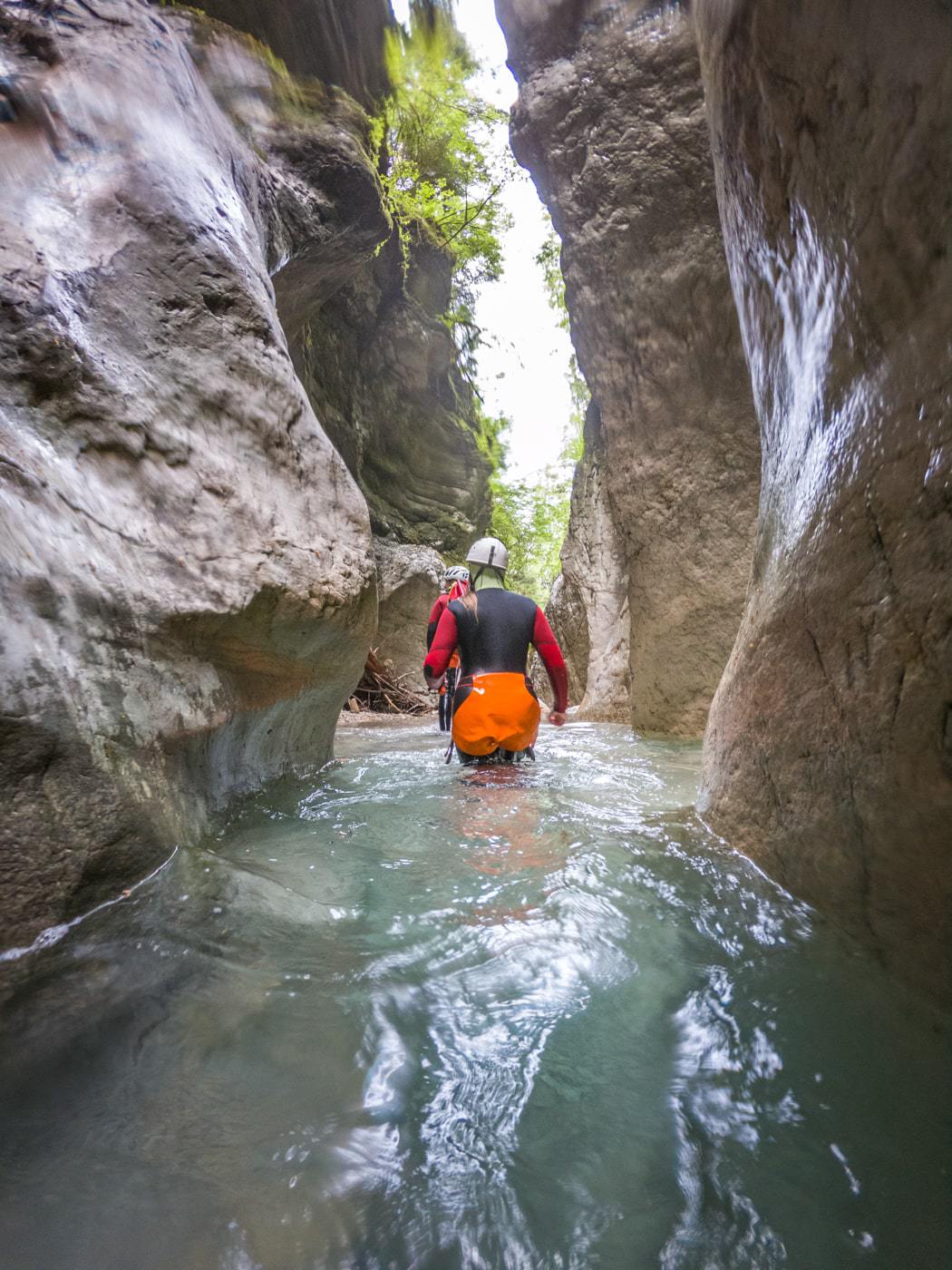women walking through a water pool while canyoning in val noana