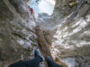 woman walking down a ledge while canyoning in trentino