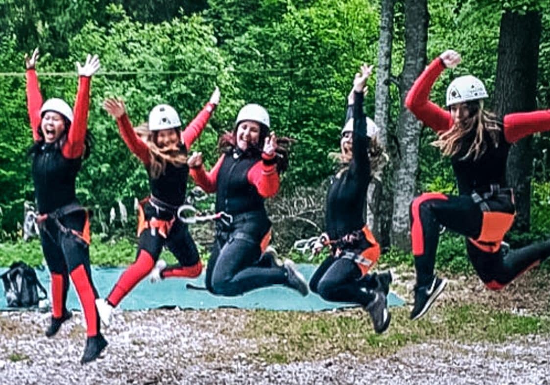 adventure girls jumping for joy in valle del vanoi