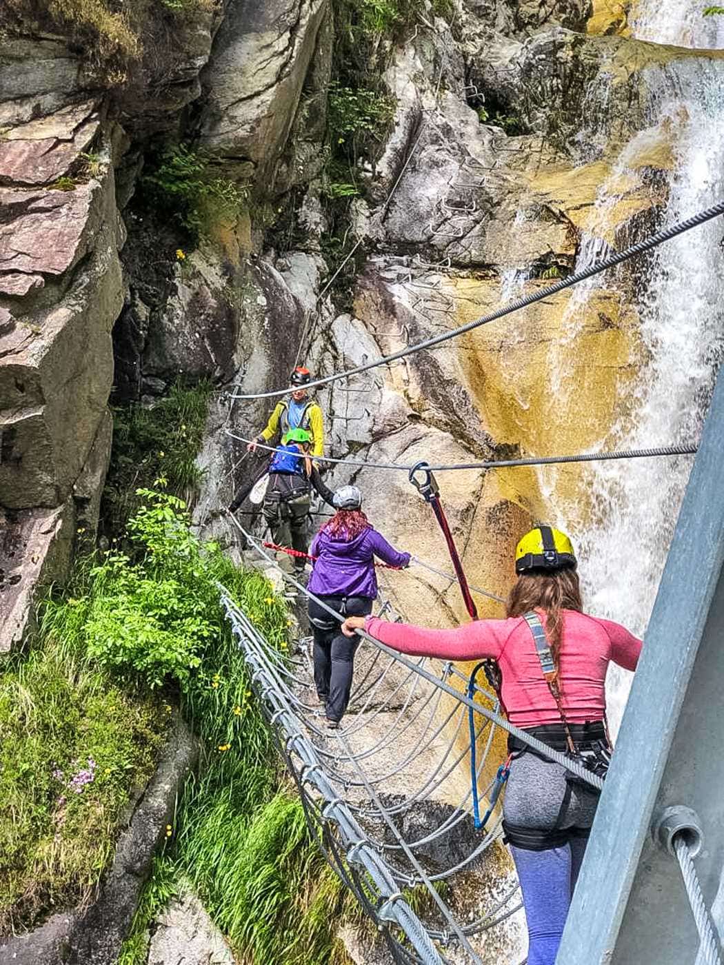 woman crossing a steel cable bridge in valle del vanoi trentino