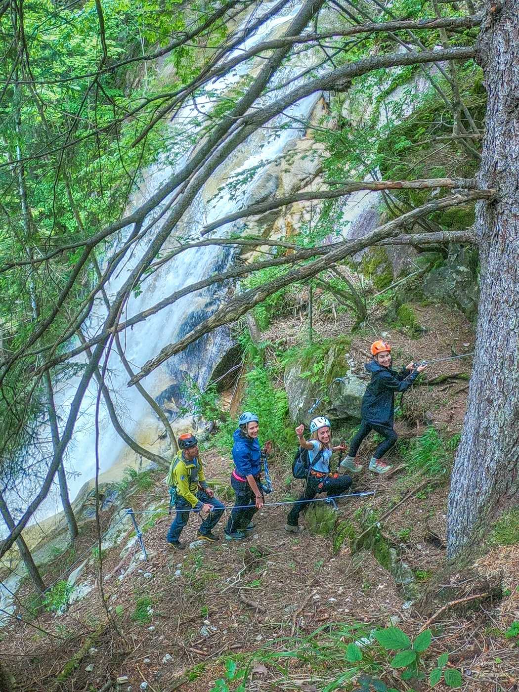 group of women hiking with a waterfall behind them