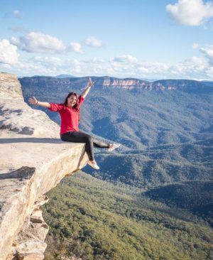 woman sitting on the edge of a rock in the blue mountains near sydney australia