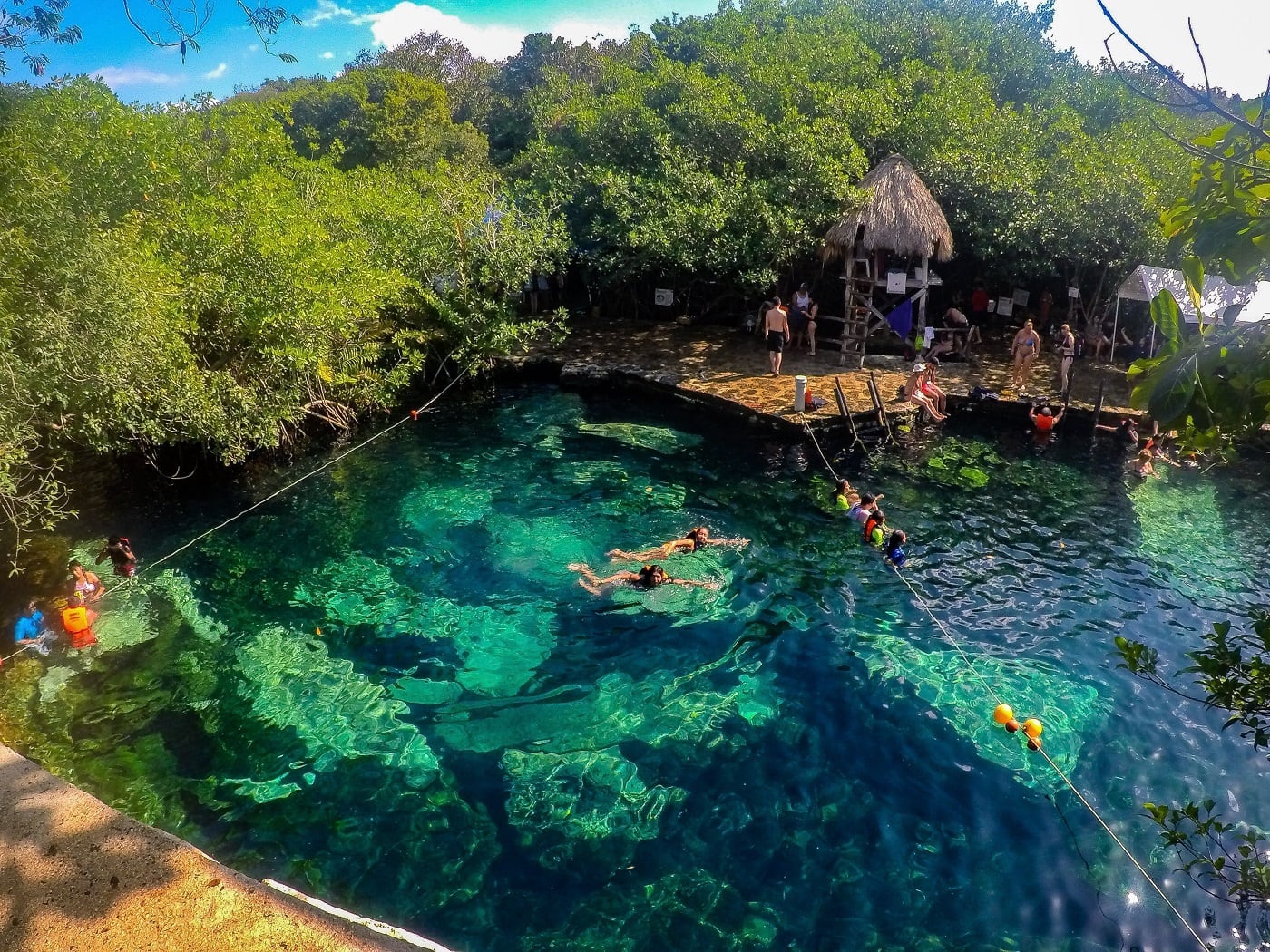 view of people hanging out in cristalino cenote in tulum
