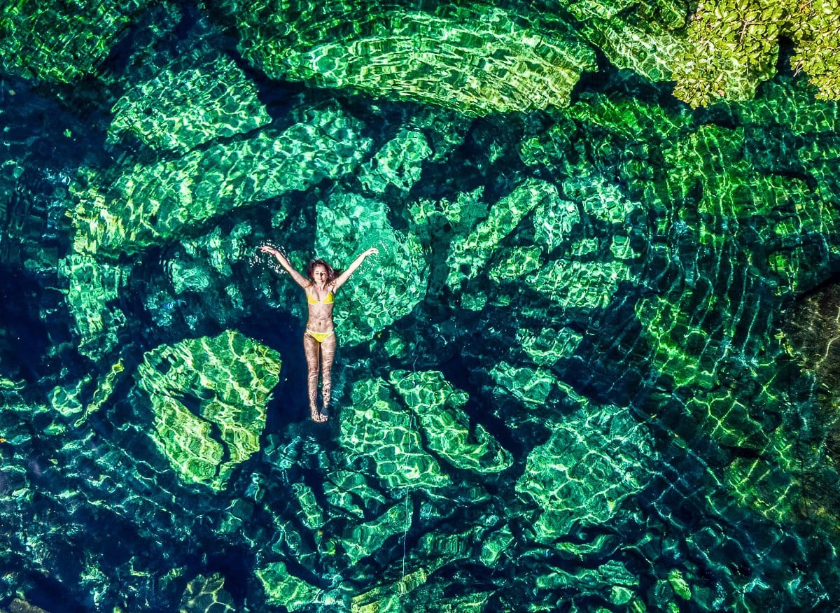 drone view of woman floating in the cristalino cenote