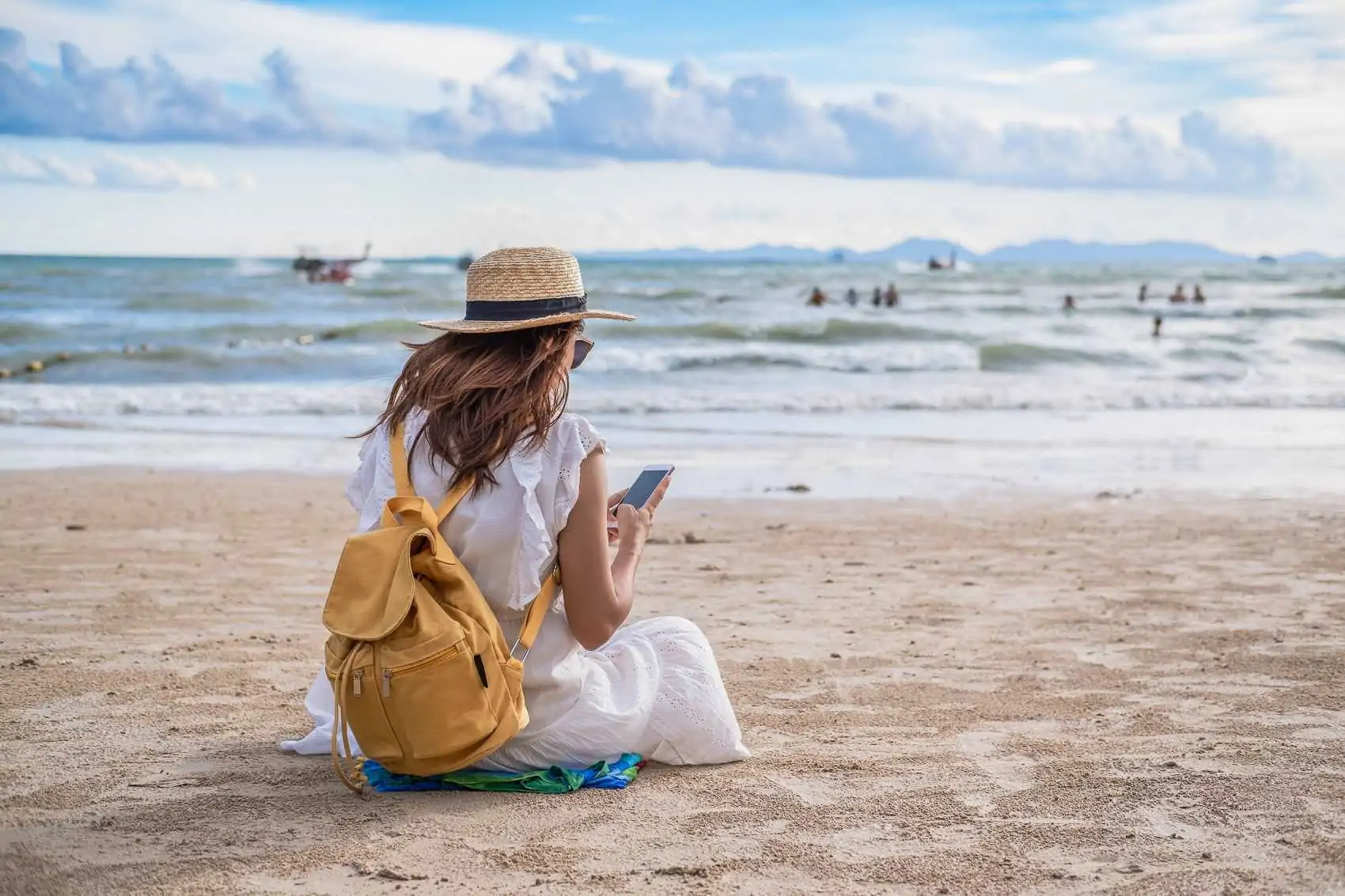 woman traveler using her smartphone at the beach